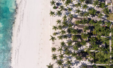 Outdoor dining at Karafuu Beach Resort under thatched umbrellas at night