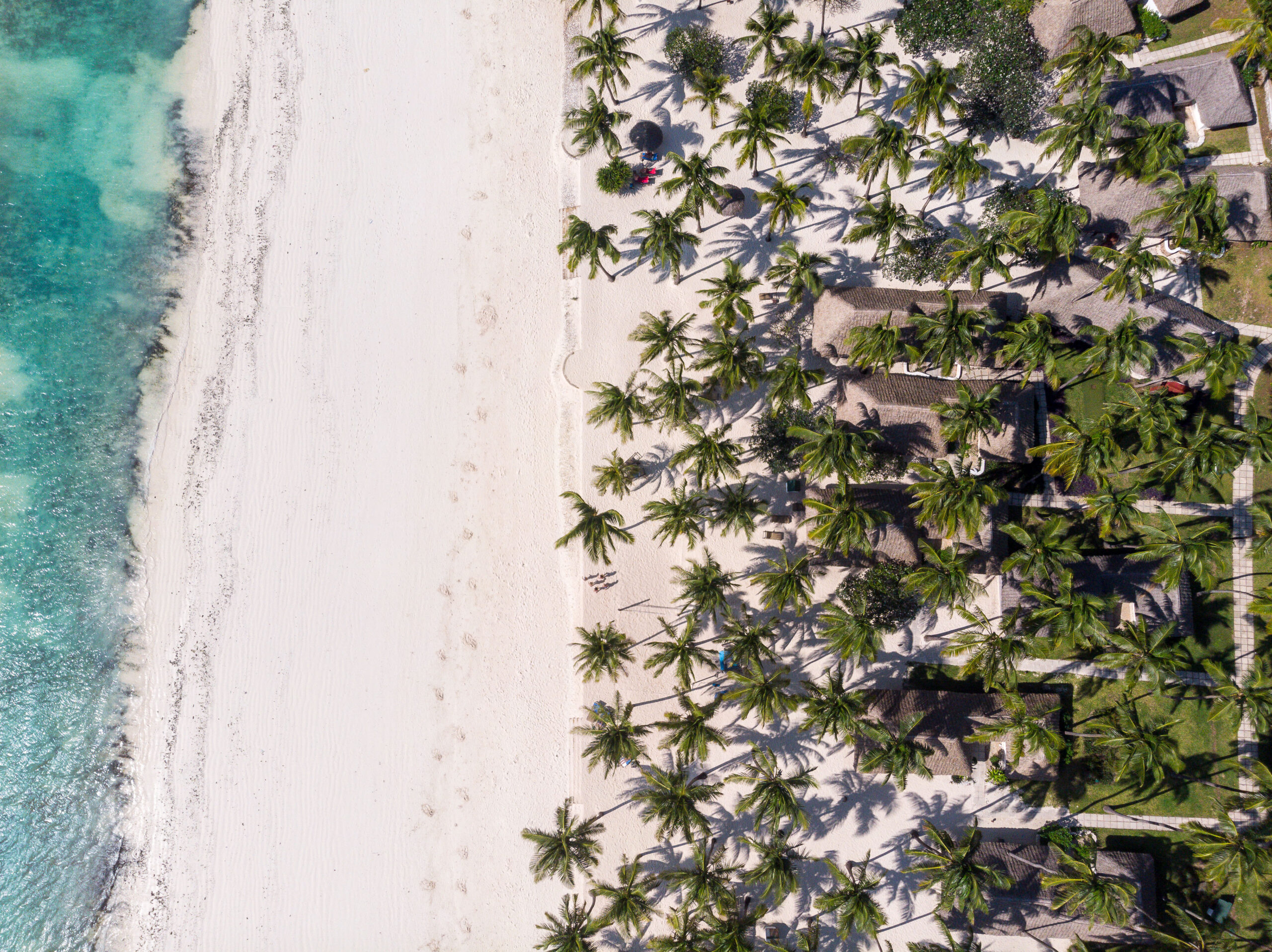 Outdoor dining at Karafuu Beach Resort under thatched umbrellas at night