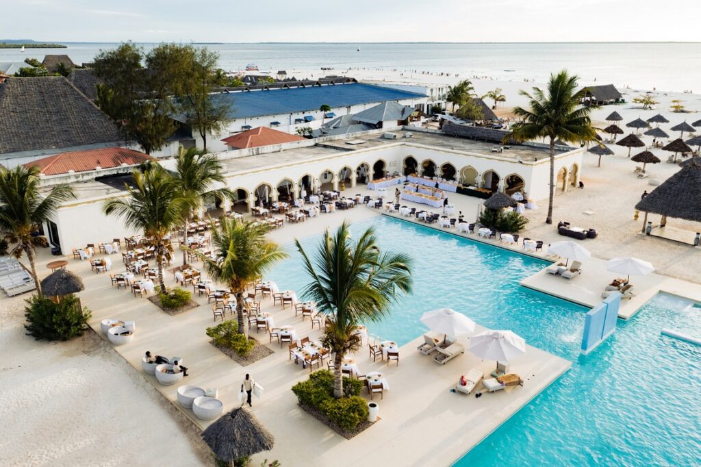 Poolside dining area with palm trees and ocean view at Gold Zanzibar resort