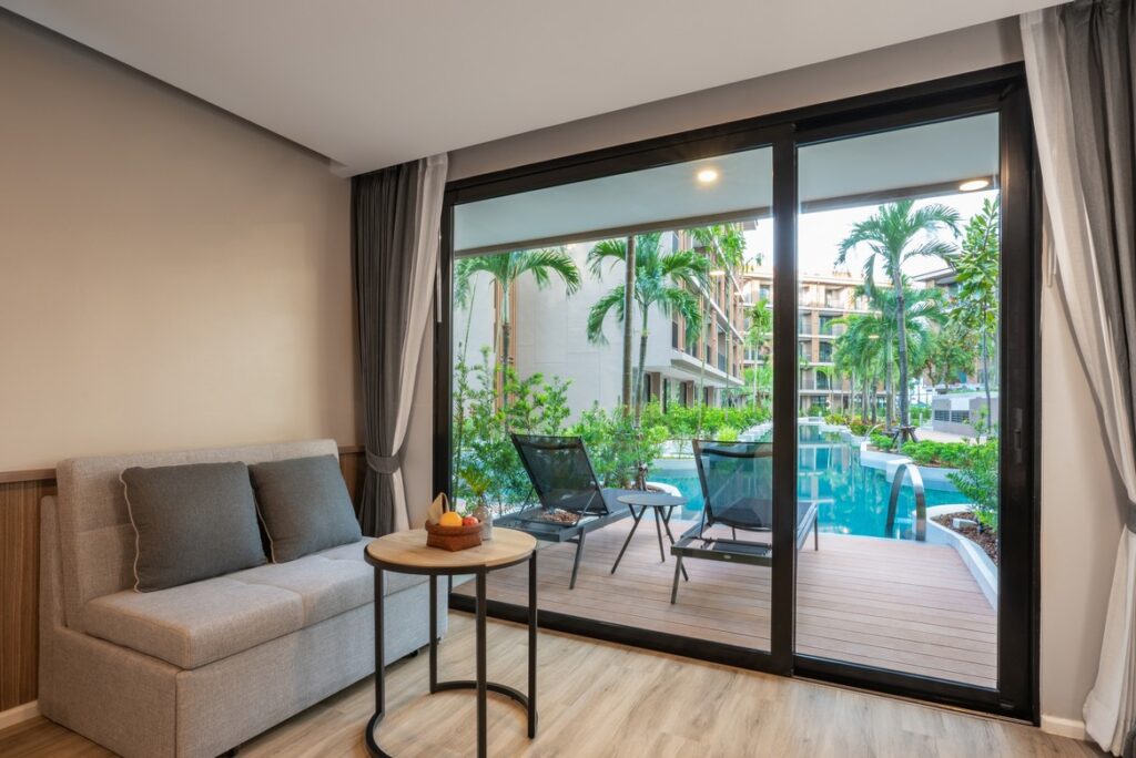 Poolside view from a cozy room with sofa seating at La Flora Khao Lak with a serene outdoor ambiance
