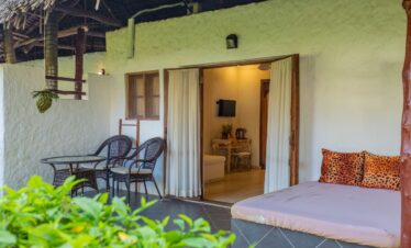 Private patio with seating at Karafuu Beach Resort overlooking lush gardens