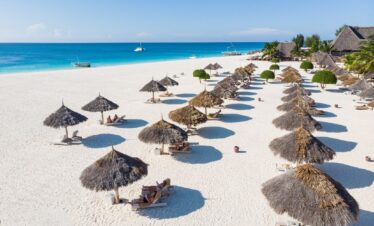 Rows of thatched umbrellas on the white sandy beach of Gold Zanzibar