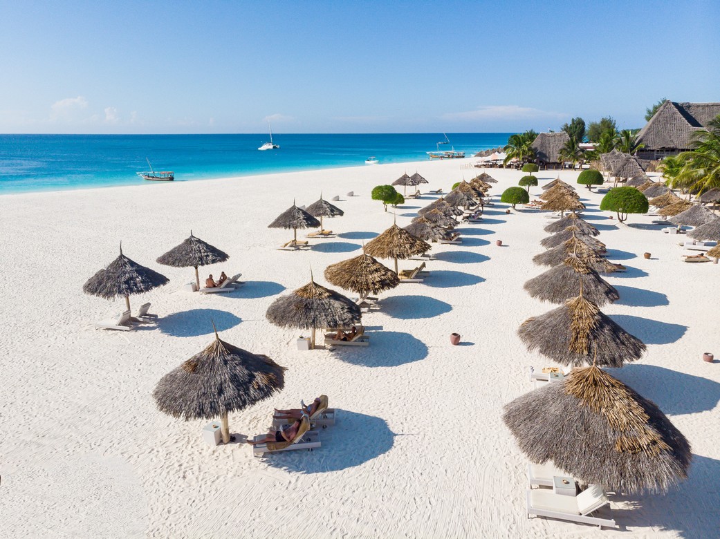 Rows of thatched umbrellas on the white sandy beach of Gold Zanzibar