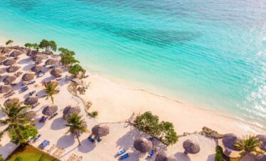 Sandies Baobab Beach Resort thatched-roof sun loungers along the beachfront