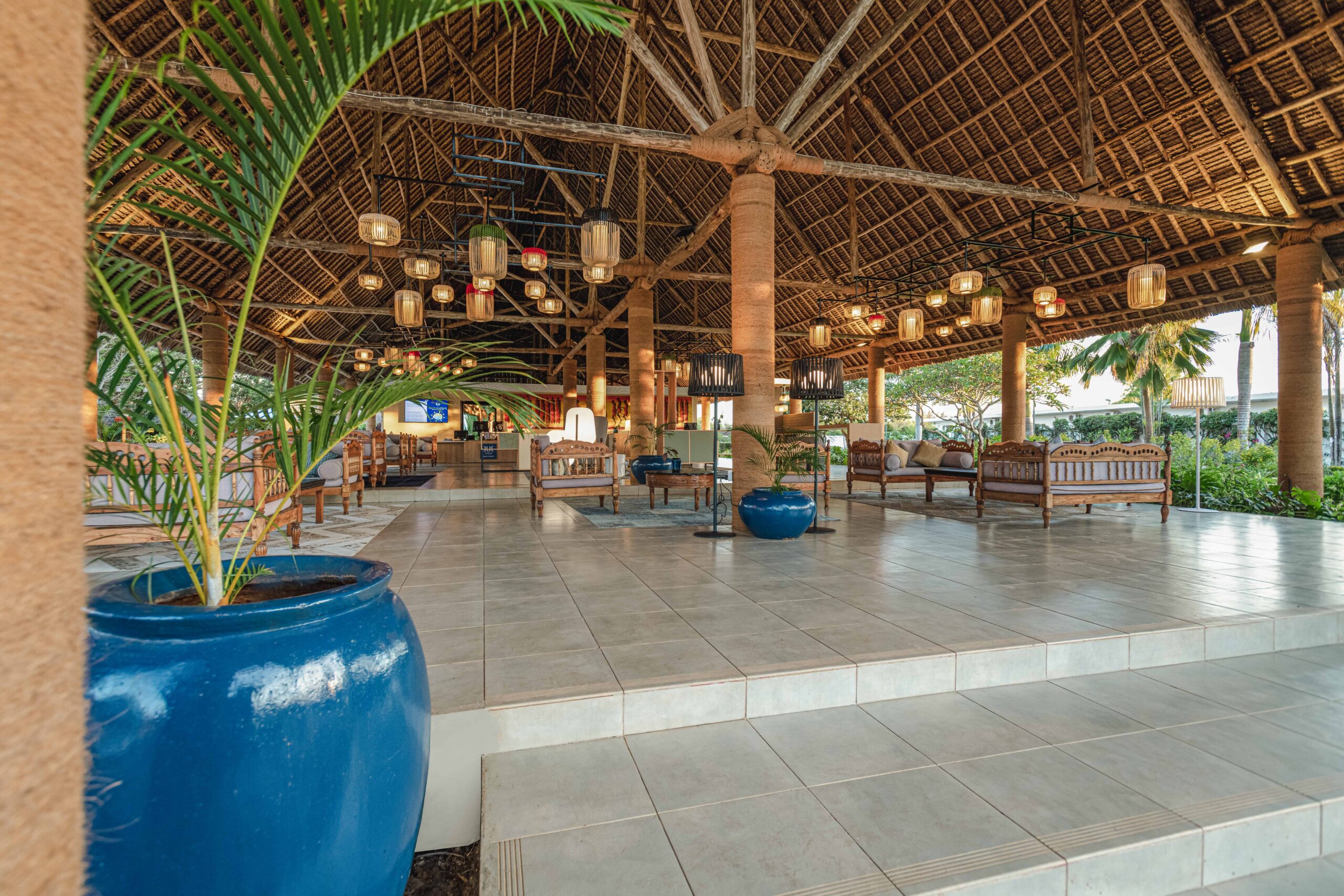 Spacious open air lobby with high thatched roof and traditional seating at Tui Blue Bahari