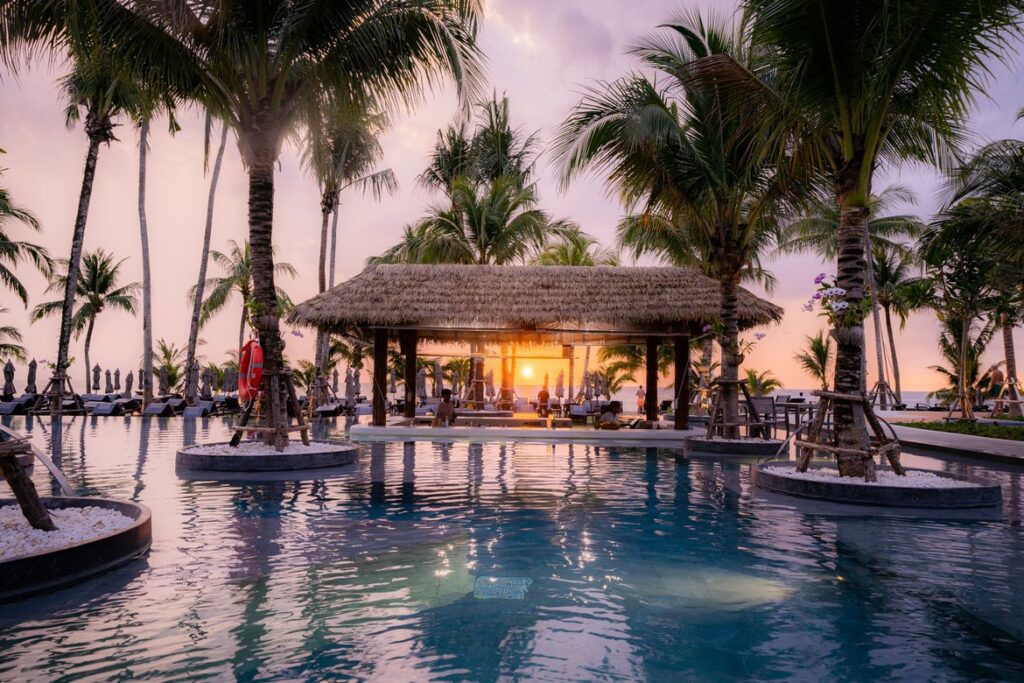 Stunning sunset view at the poolside bar surrounded by palm trees at La Flora Khao Lak