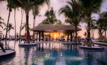 Stunning sunset view at the poolside bar surrounded by palm trees at La Flora Khao Lak