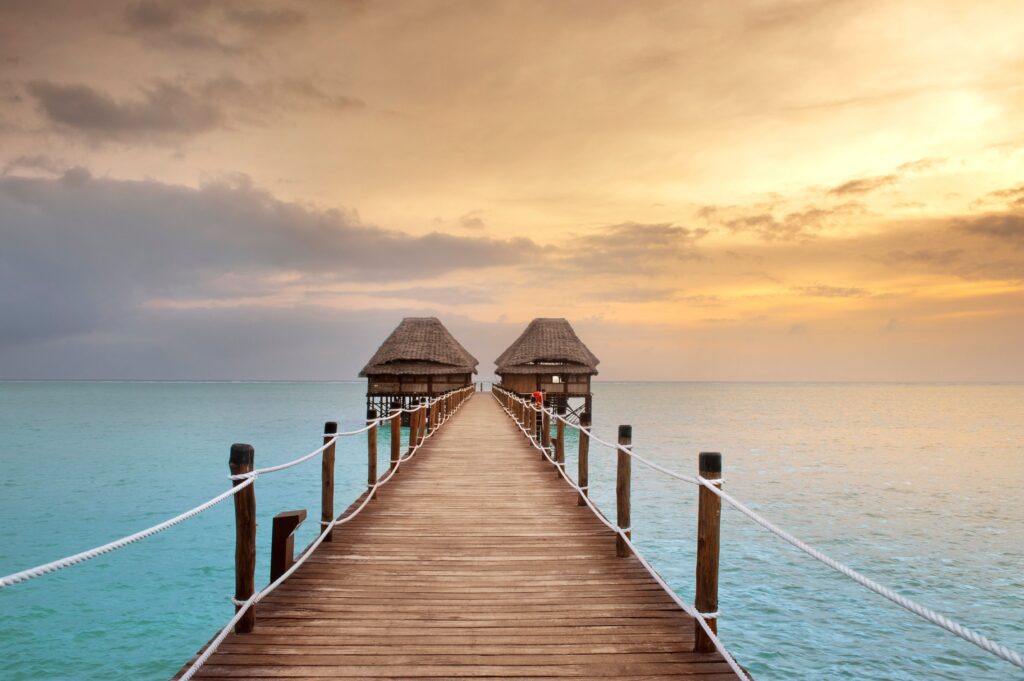Sunset over the wooden pier at Melia Zanzibar leading to the ocean