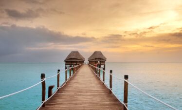 Sunset over the wooden pier at Melia Zanzibar leading to the ocean