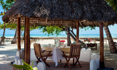 Thatched roof gazebo at Diamonds Mapenzi Beach Resort set for beachfront dining