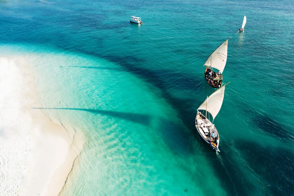 Traditional dhows sailing on turquoise waters near the beach at Gold Zanzibar