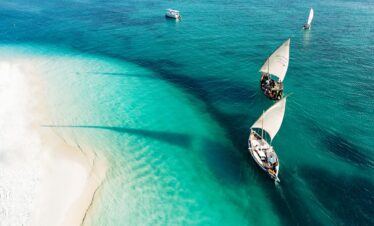 Traditional dhows sailing on turquoise waters near the beach at Gold Zanzibar