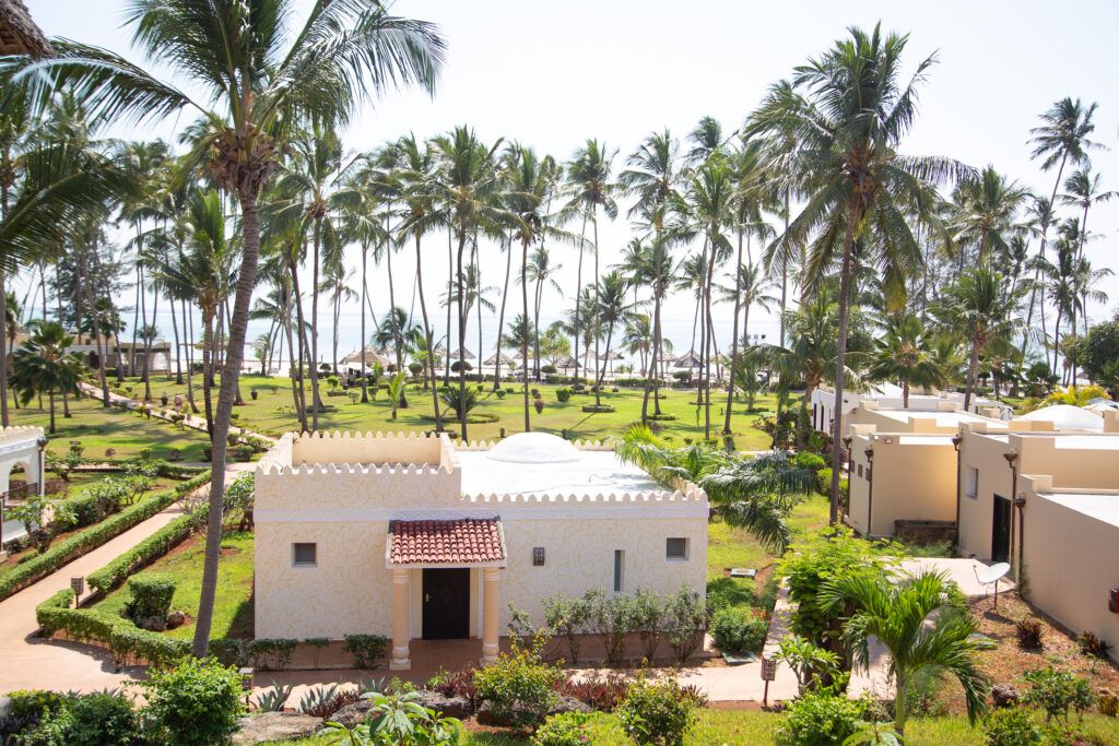 View of lush gardens with palm trees leading to the ocean at Tui Blue Bahari resort