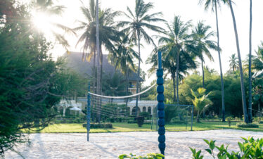 Volleyball net on a sandy court surrounded by palm trees at Tui Blue Bahari