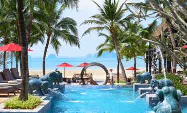 Poolside seating and palm trees at Amari Vogue Krabi resort
