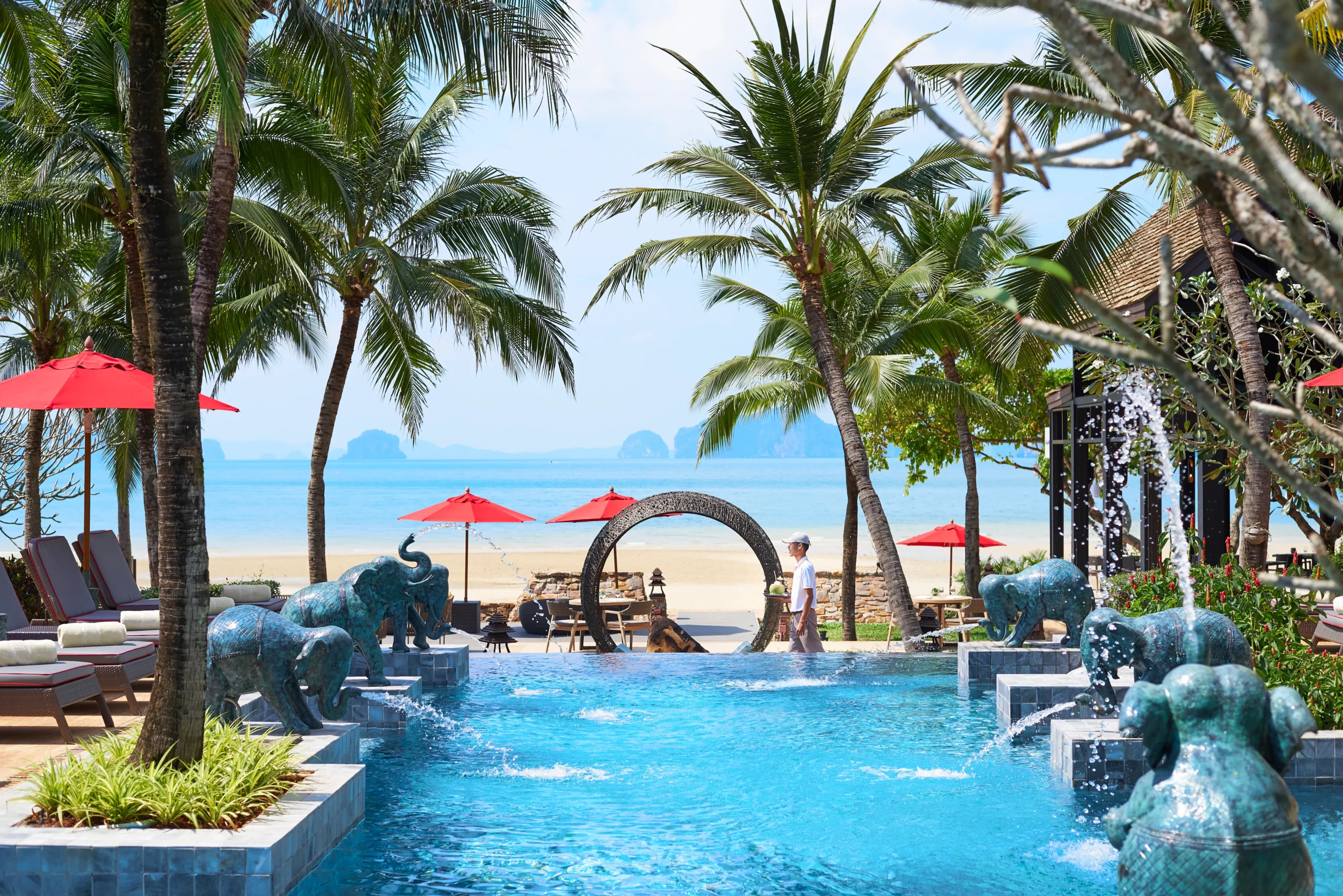 Poolside seating and palm trees at Amari Vogue Krabi resort